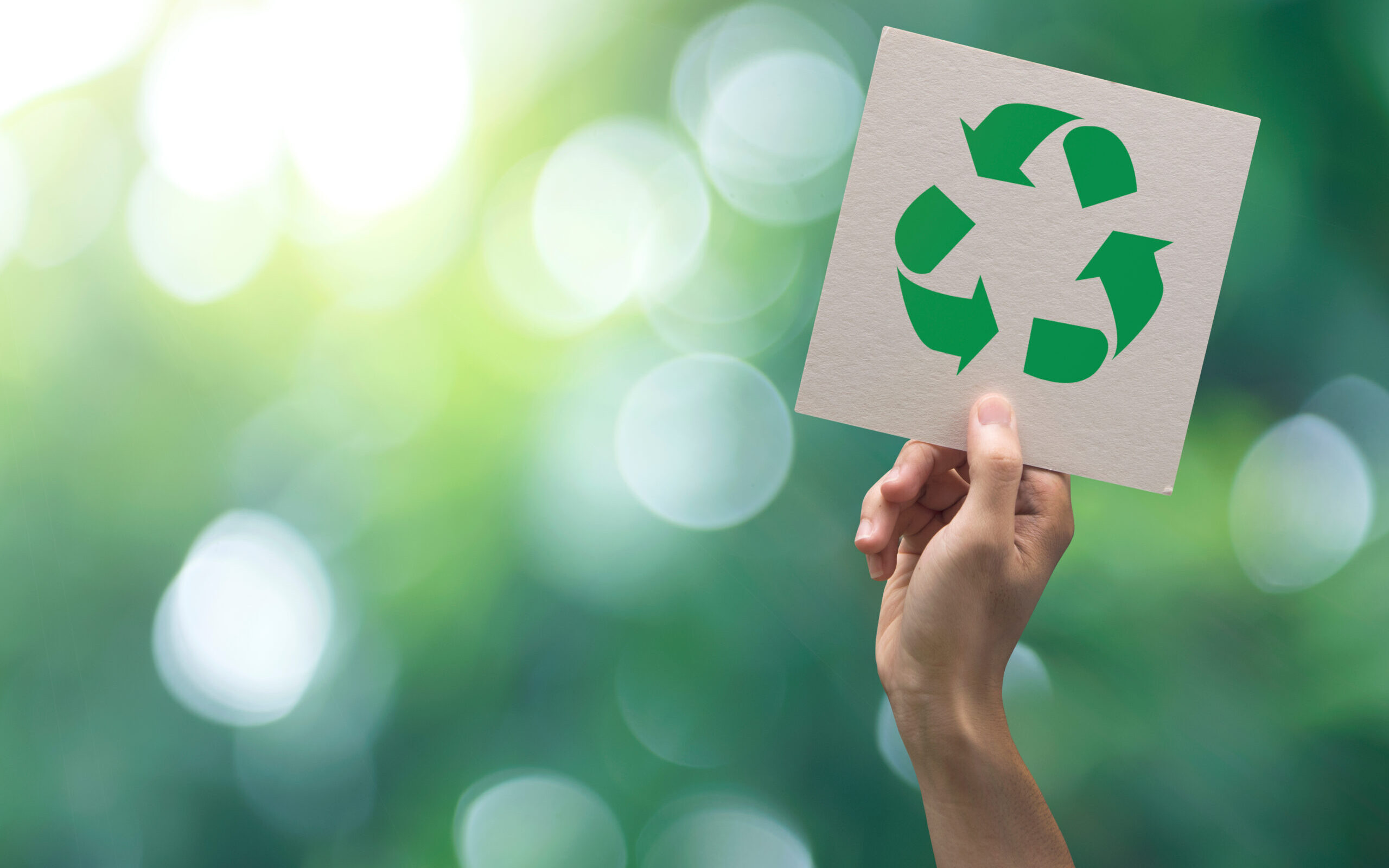 Hand hebt Recycling-Schild hoch, für SITECs Maßnahmen für Langlebigkeit und Recycling